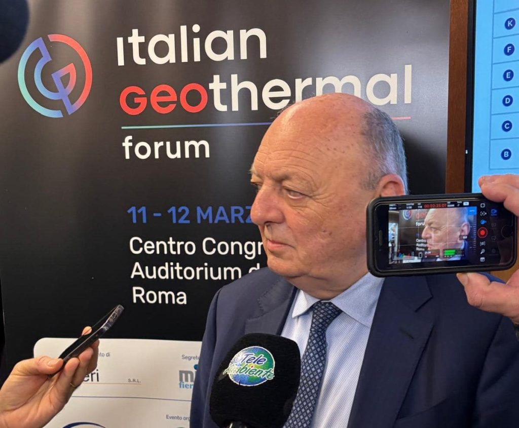 Gilberto Pichetto Fratin, ministro dell'Ambiente, parla al podio del Forum con slide di sfondo su geotermia e decarbonizzazione